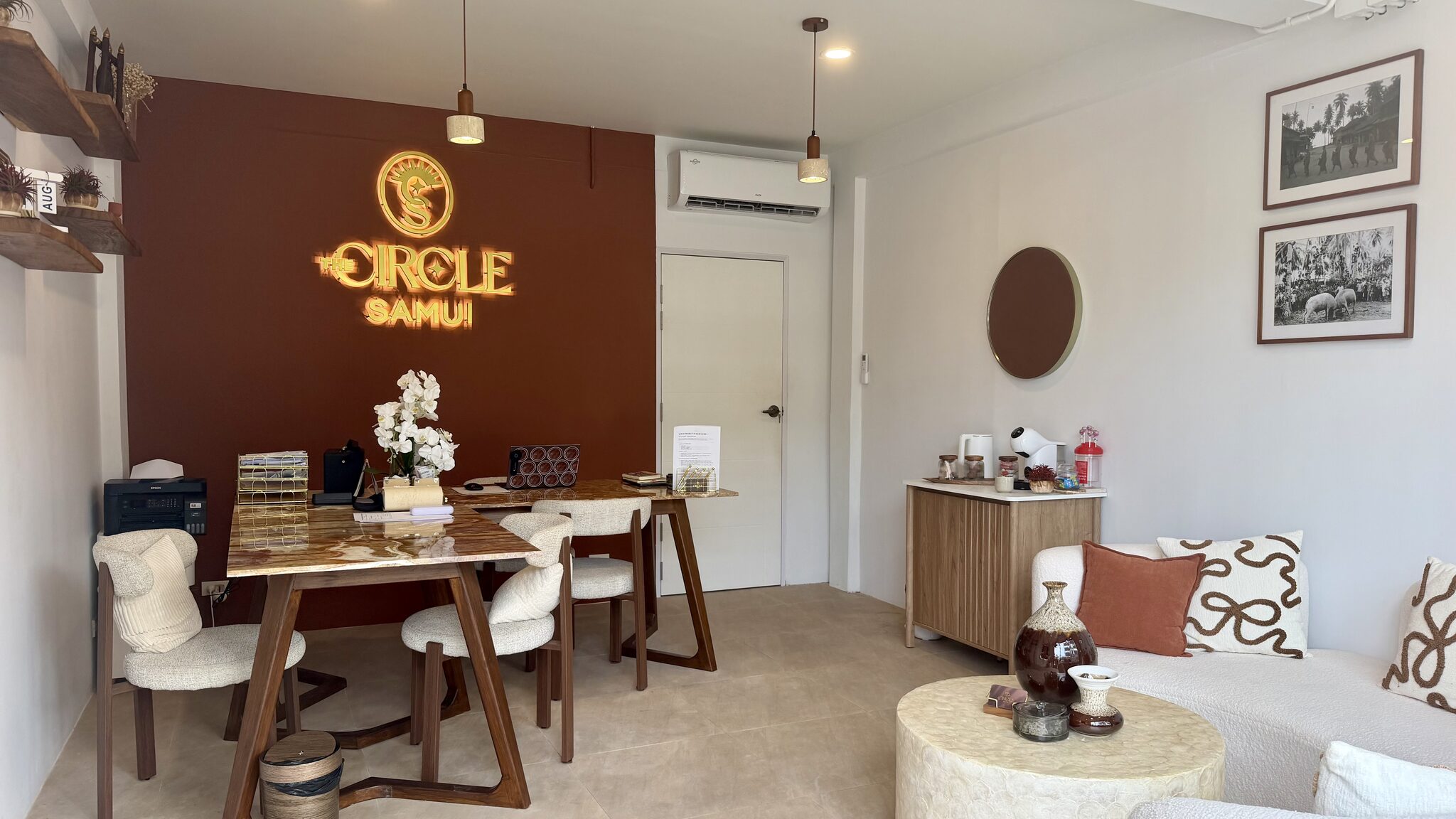 Le bureau de The Circle Samui à Koh Samui, enseigne lumineuse allumée au-dessus de la table de réception