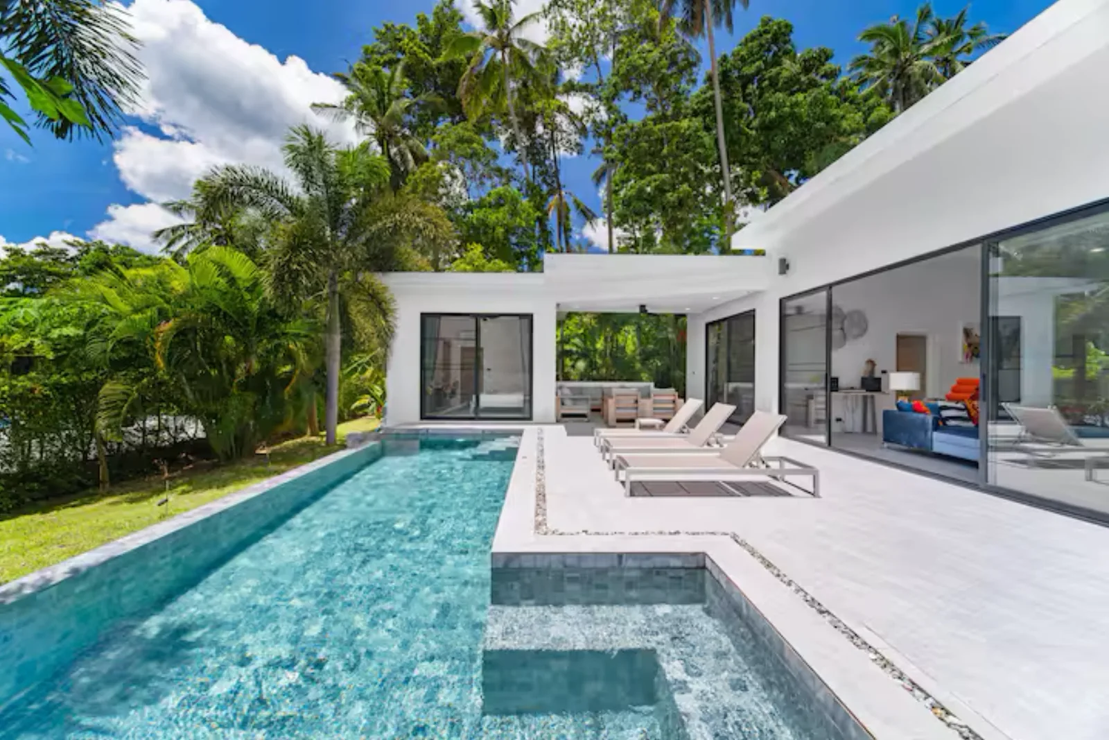 Villa de vacances à Koh Samui, longue piscine privée bordée de transats et de palmiers