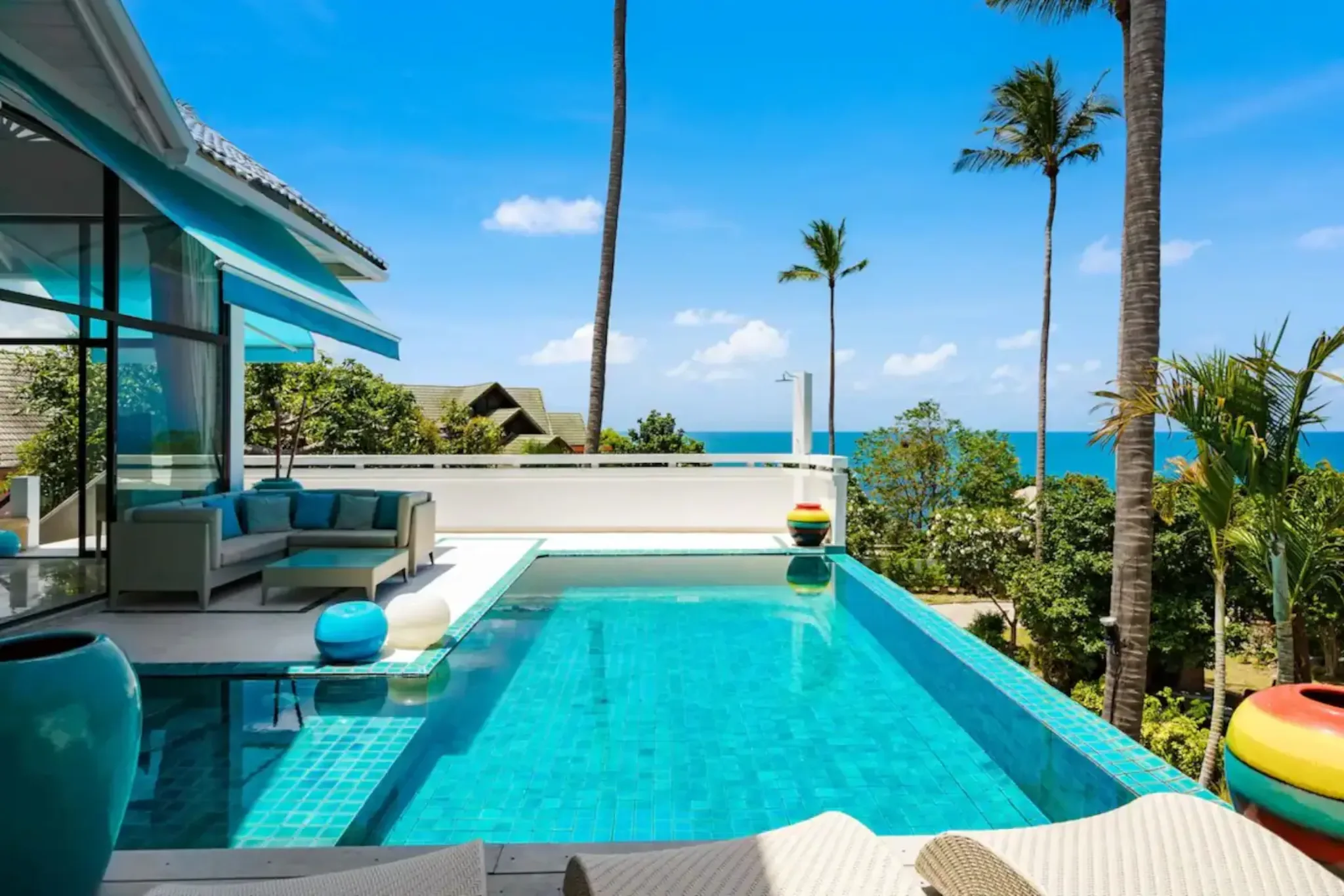 Piscine à débordement bordée de cocotiers ouverte sur la mer, à Koh Samui