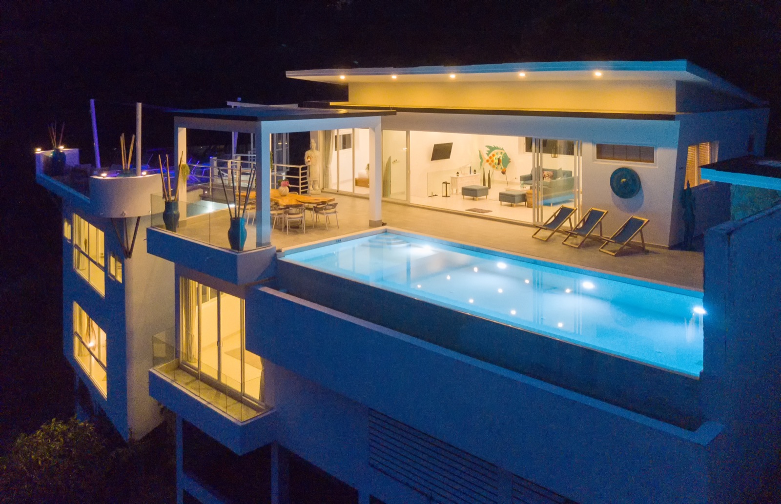 Terrasse et piscine à débordement de Villa Meya éclairées de nuit